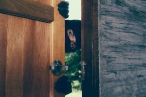 ladrón entrando a una casa sin puerta blindada