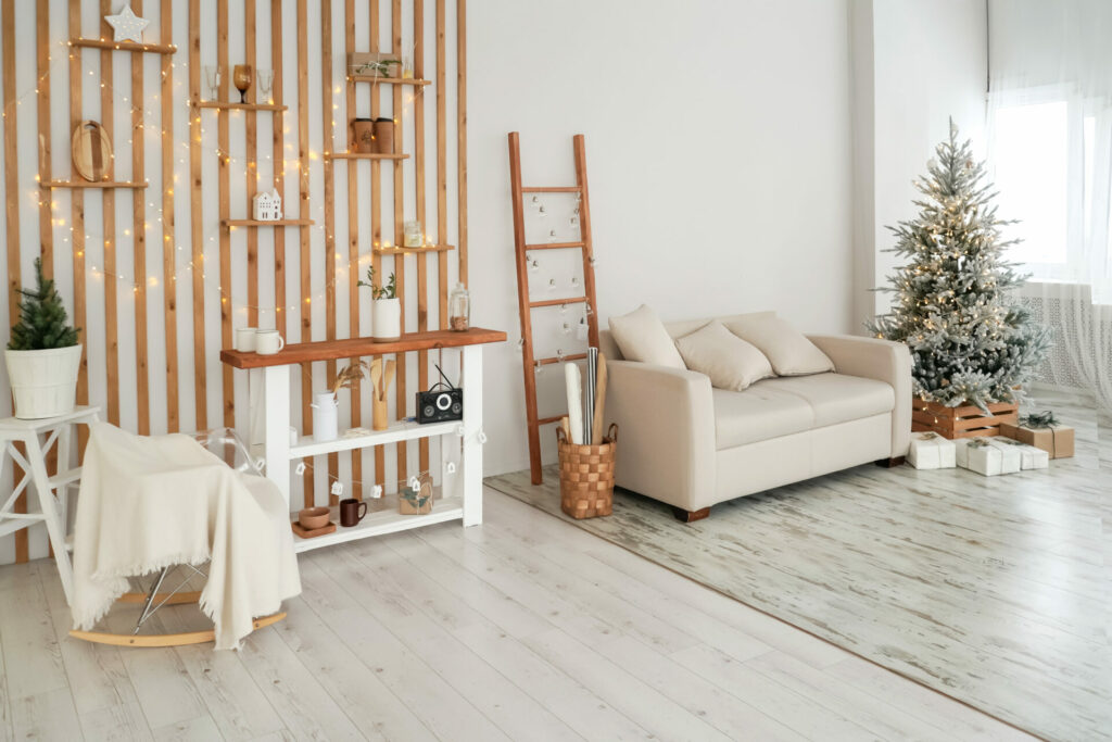 Decoración navideña en ambientes de madera con centro de mesa de piñas, ramas de abeto y detalles dorados sobre mesa de nogal