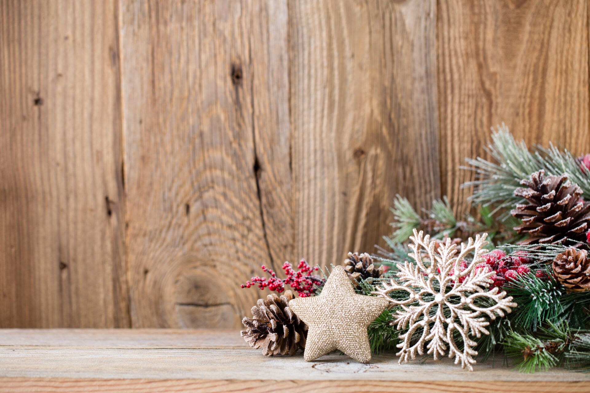 Decoración navideña en ambientes de madera con guirnaldas naturales, velas y adornos en tonos cálidos sobre mobiliario de roble